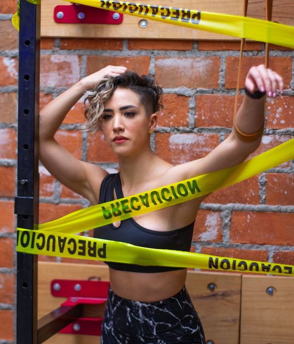 Athletic woman performing dynamic exercises in a dark studio setting.